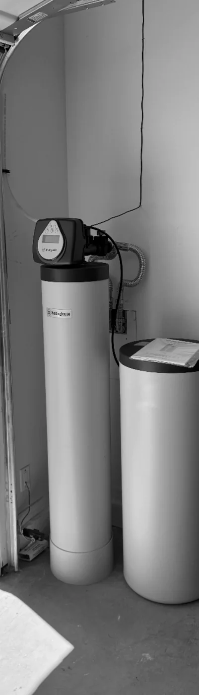 Whole-home treatment tanks installed near a residential garage water line