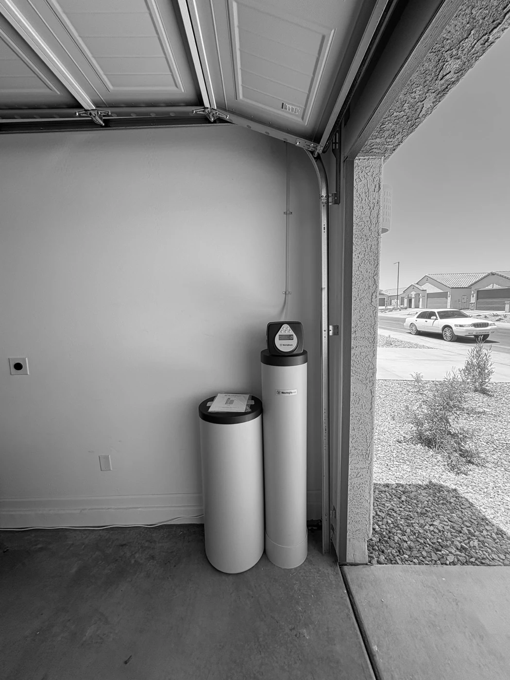 Whole-home water treatment equipment installed inside a residential garage