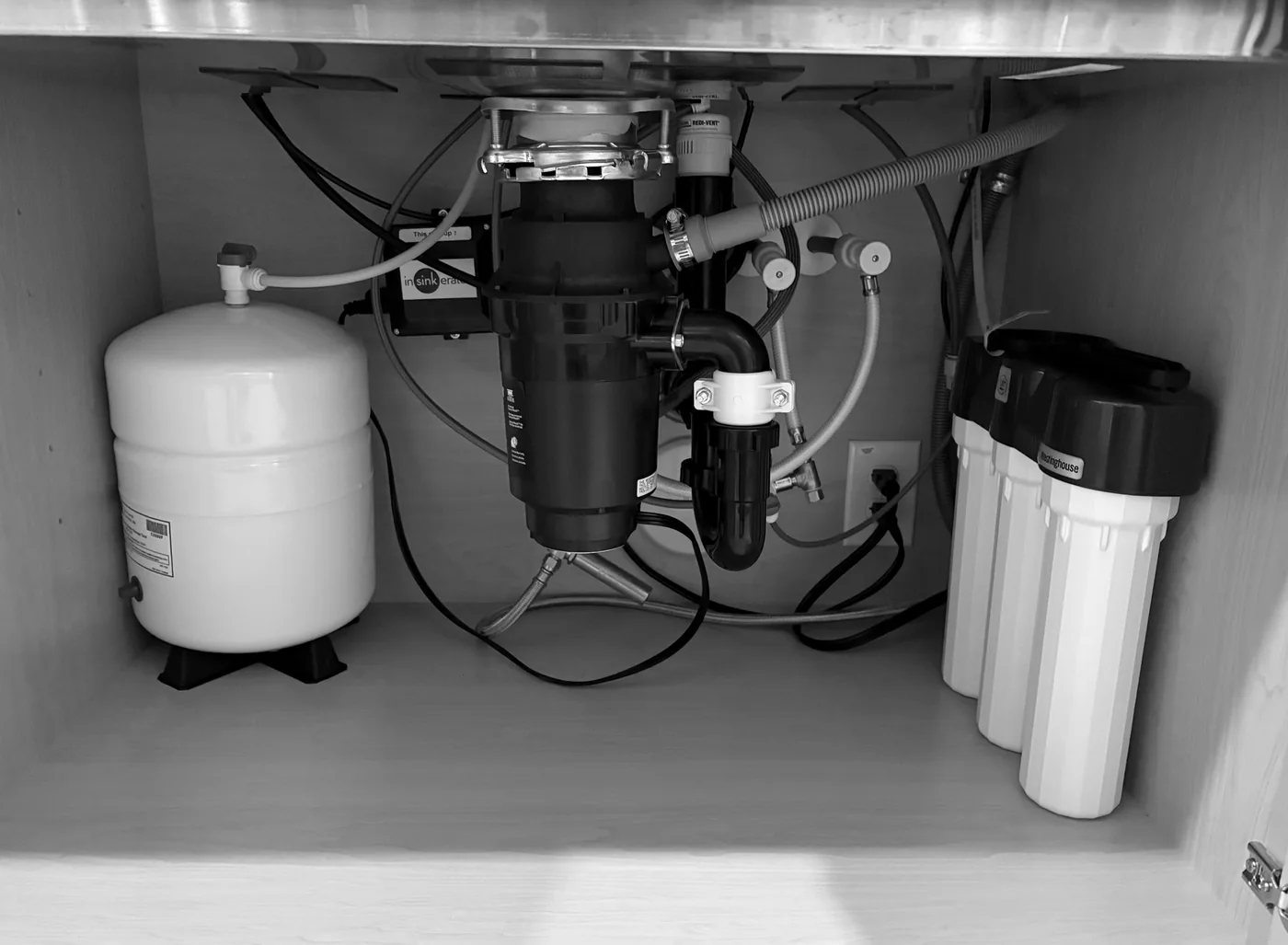 Reverse osmosis storage tank and multistage filters beneath a kitchen sink